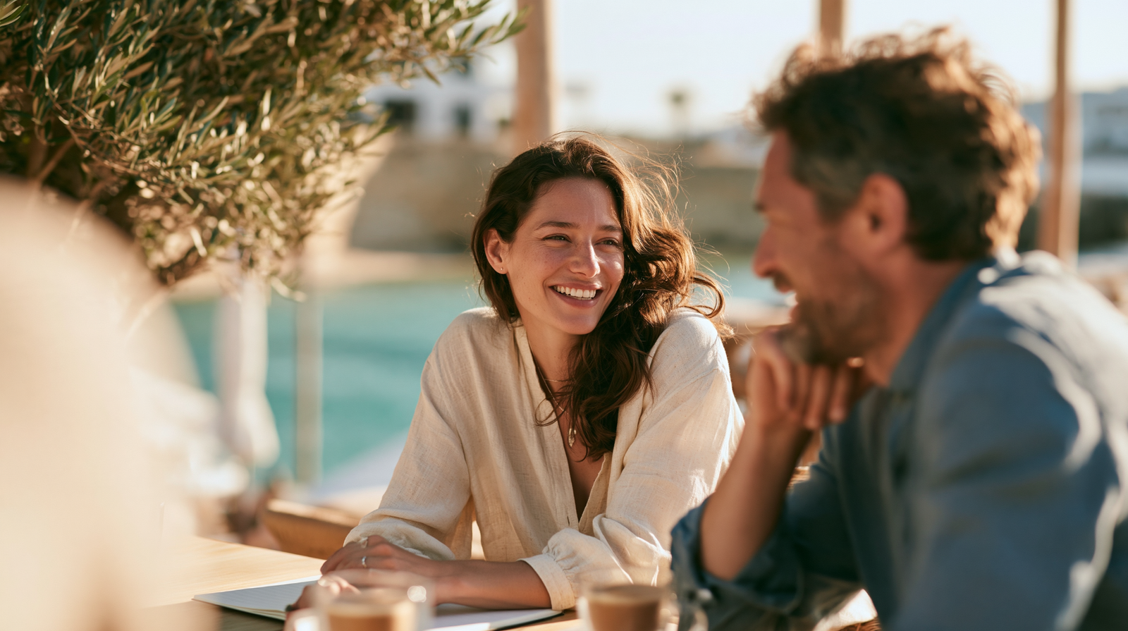A woman and a man talking on a sunlit terrace