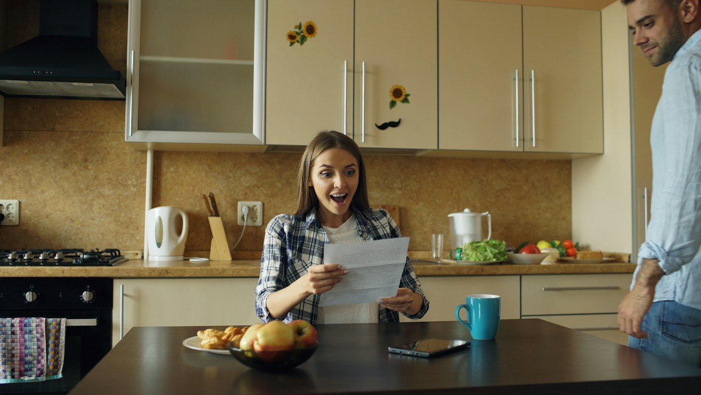 Couple reading a letter together at their kitchen table