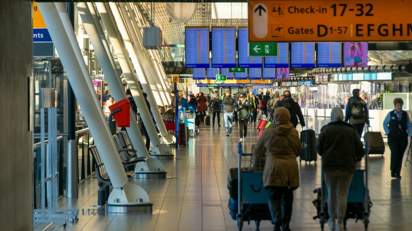 Travellers walking through an airport check-in hall